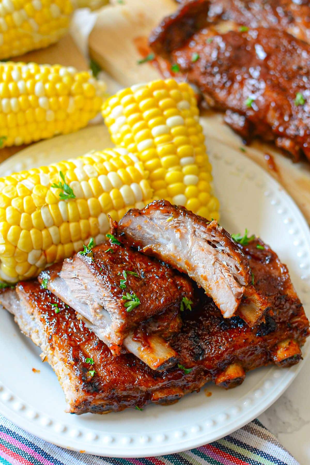Ribs on a plate with corn on the cob.