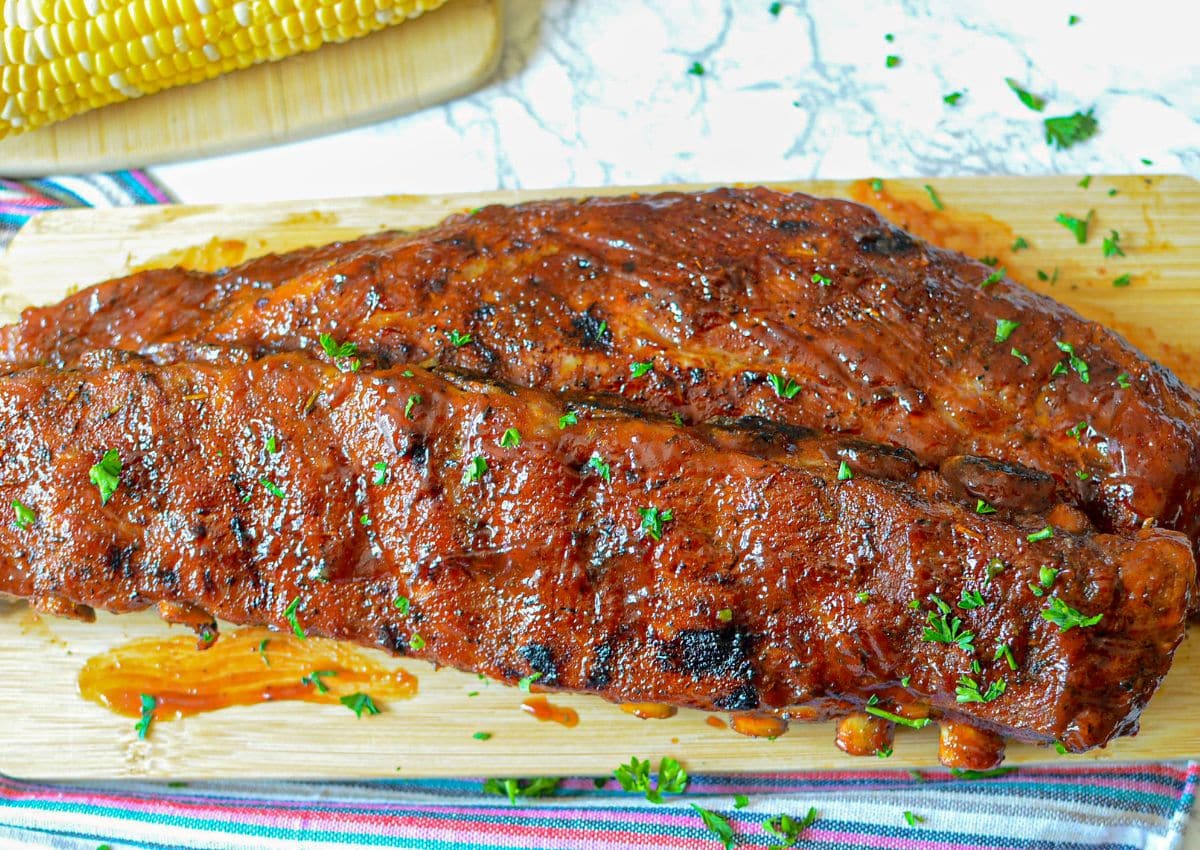 Two slabs of ribs on a cutting board.
