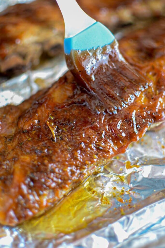 BBQ sauce being brushed on meat.