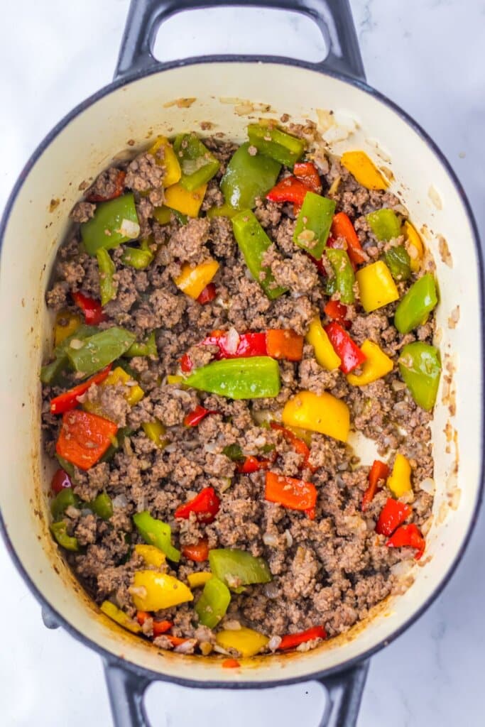 Beef and vegetables being cooked in a pot. 