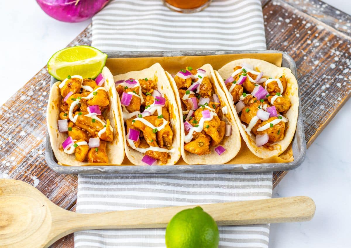 Garlic honey bbq chicken tacos on a metal serving tray.