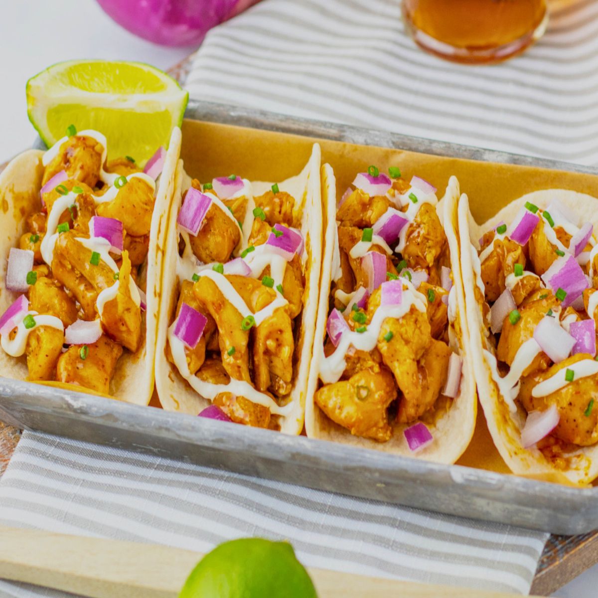 Garlic honey bbq chicken tacos on a metal serving tray.