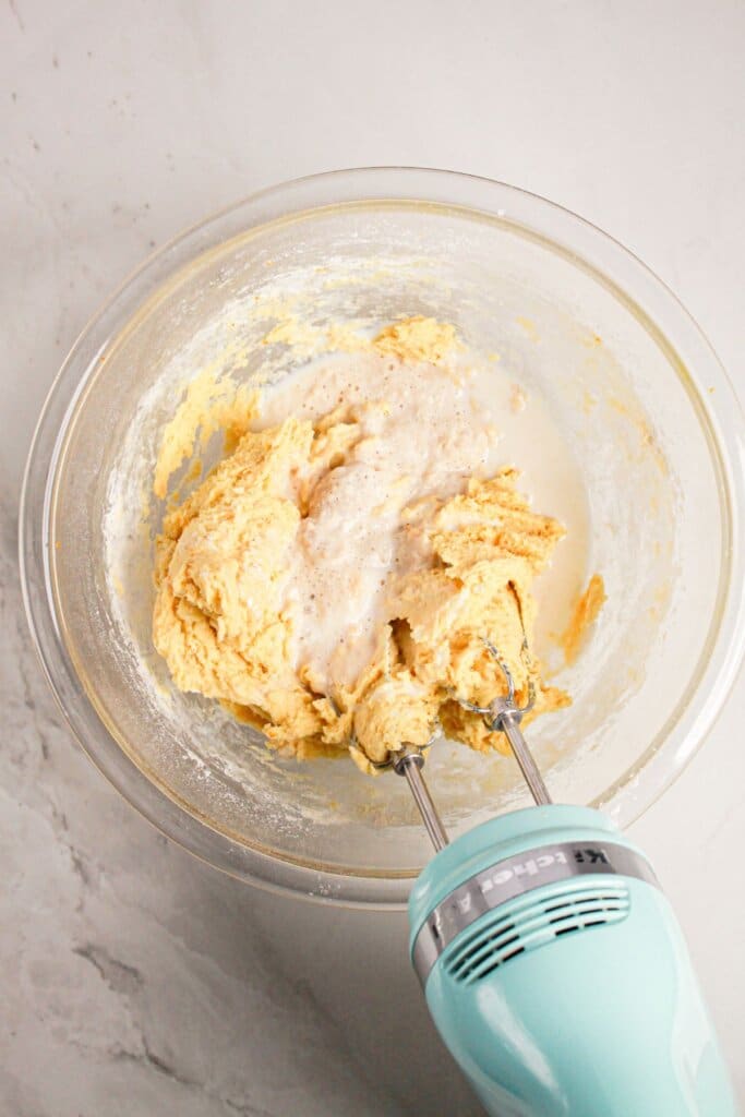 Yeast being added to batter in a glass bowl.