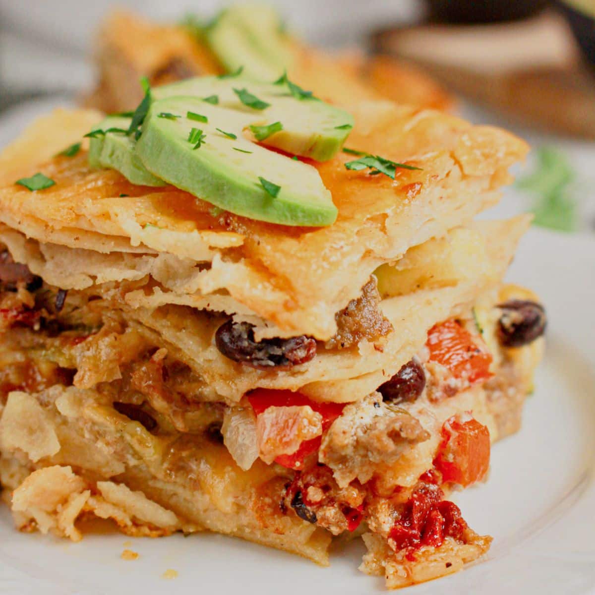 Slice of ground beef enchilada casserole on a small plate.