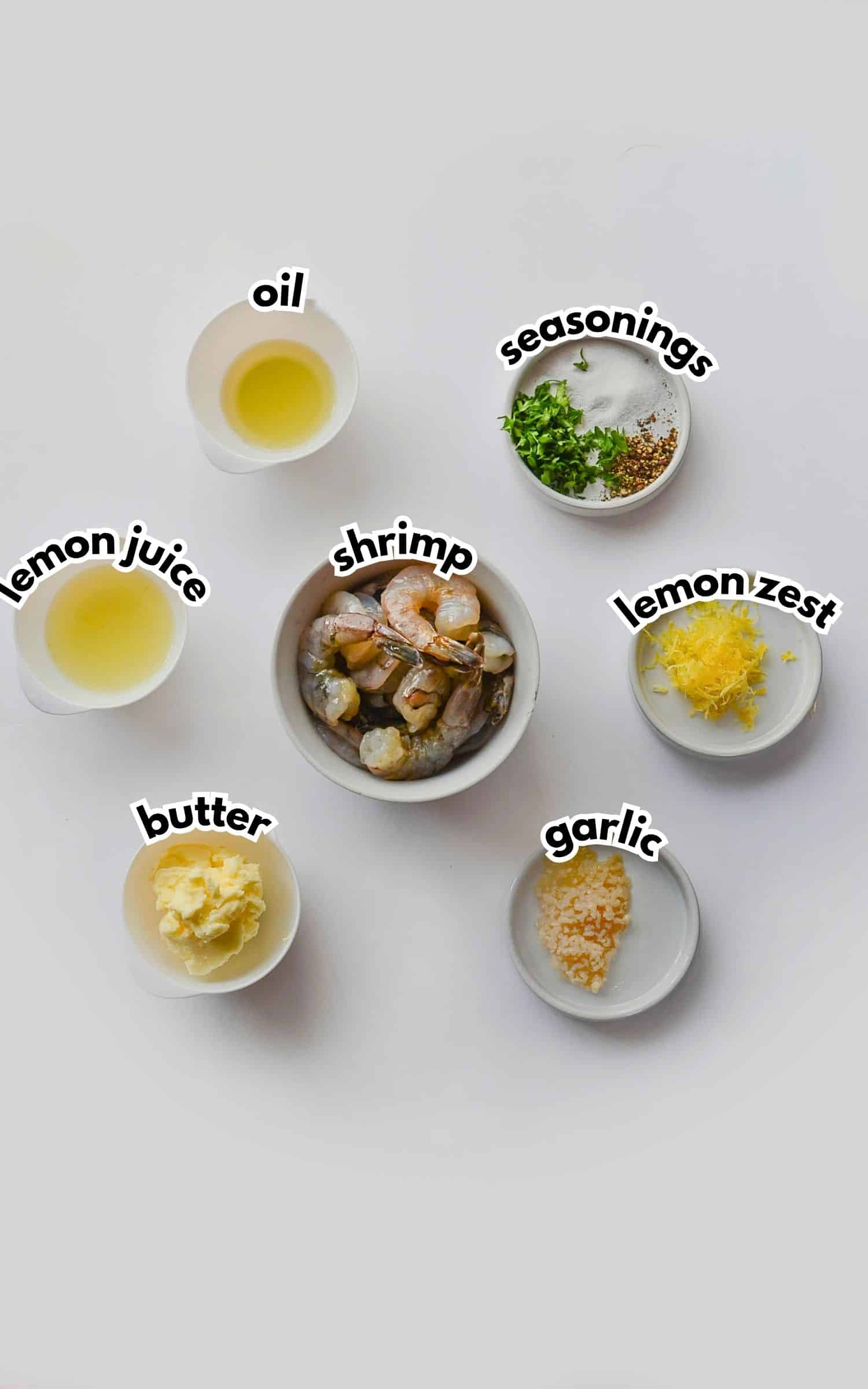 Bowls of ingredients labelled with text on a counter.