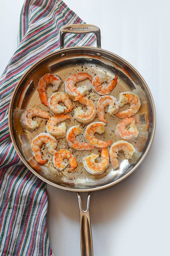 Seafood being cooked in a skillet.