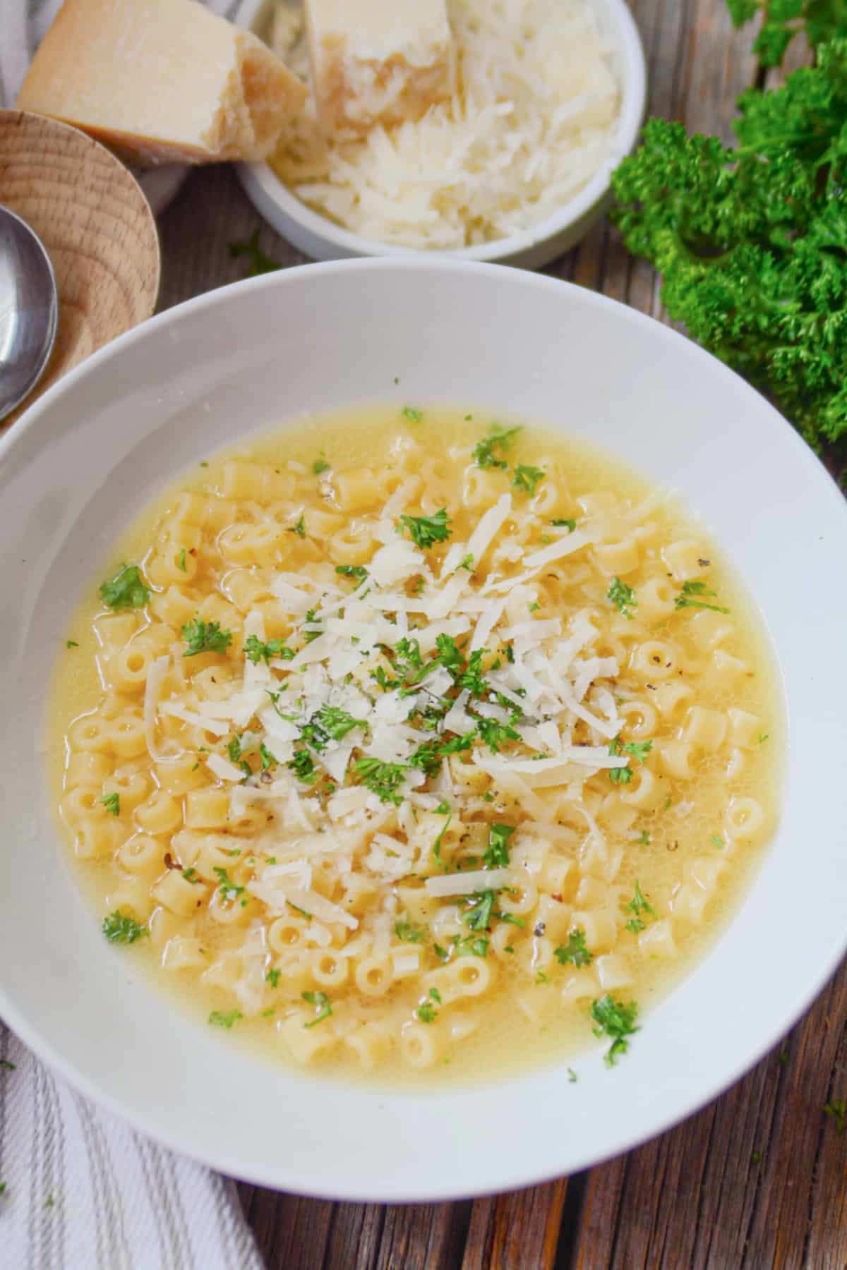 White bowl of parmesan pasta soup.
