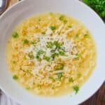 White bowl of parmesan pasta soup.