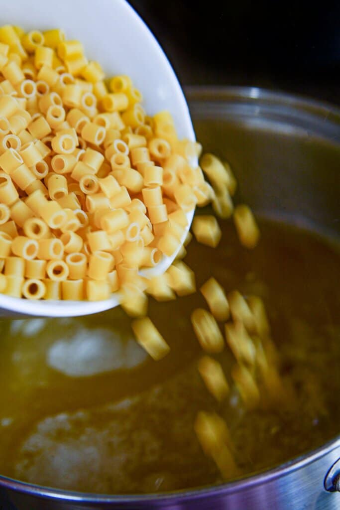 Noodles being added to a pot.