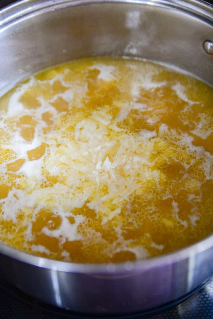Broth and noodles in a pot.