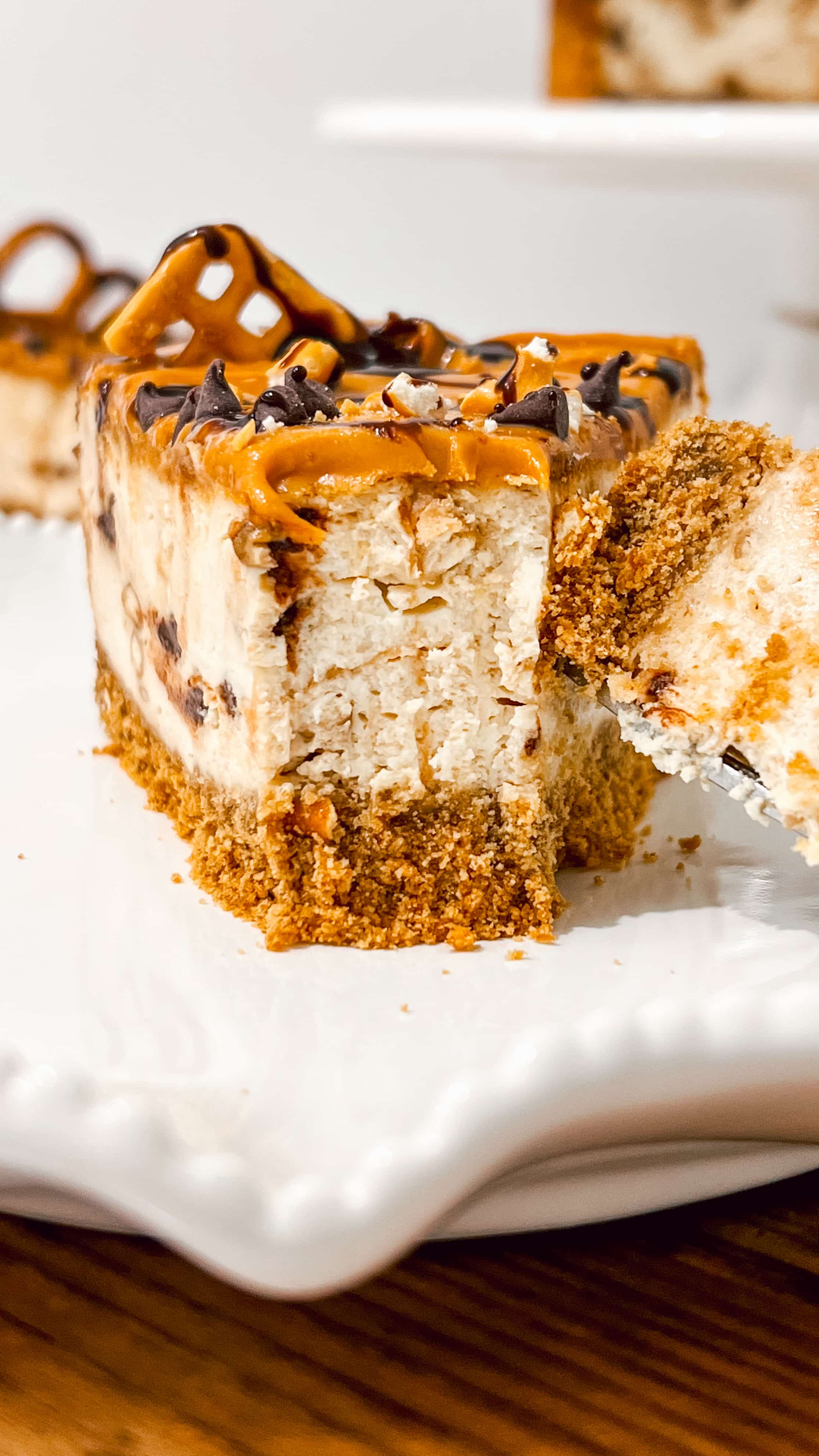 Close up of cheesecake with a bite taken out of it.