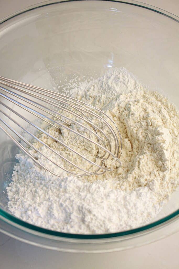 Dry ingredients being whisked in a glass bowl.