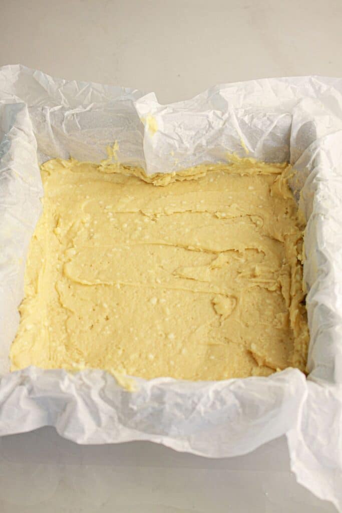 Batter being spread in a baking pan.