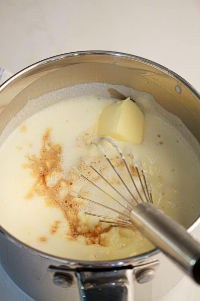 Butter and vanilla being mixed in a saucepan.