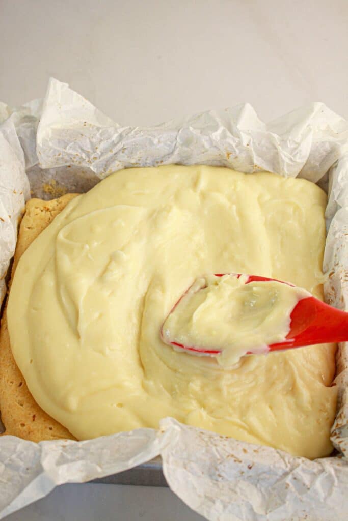 Custard being spread on top of dessert.
