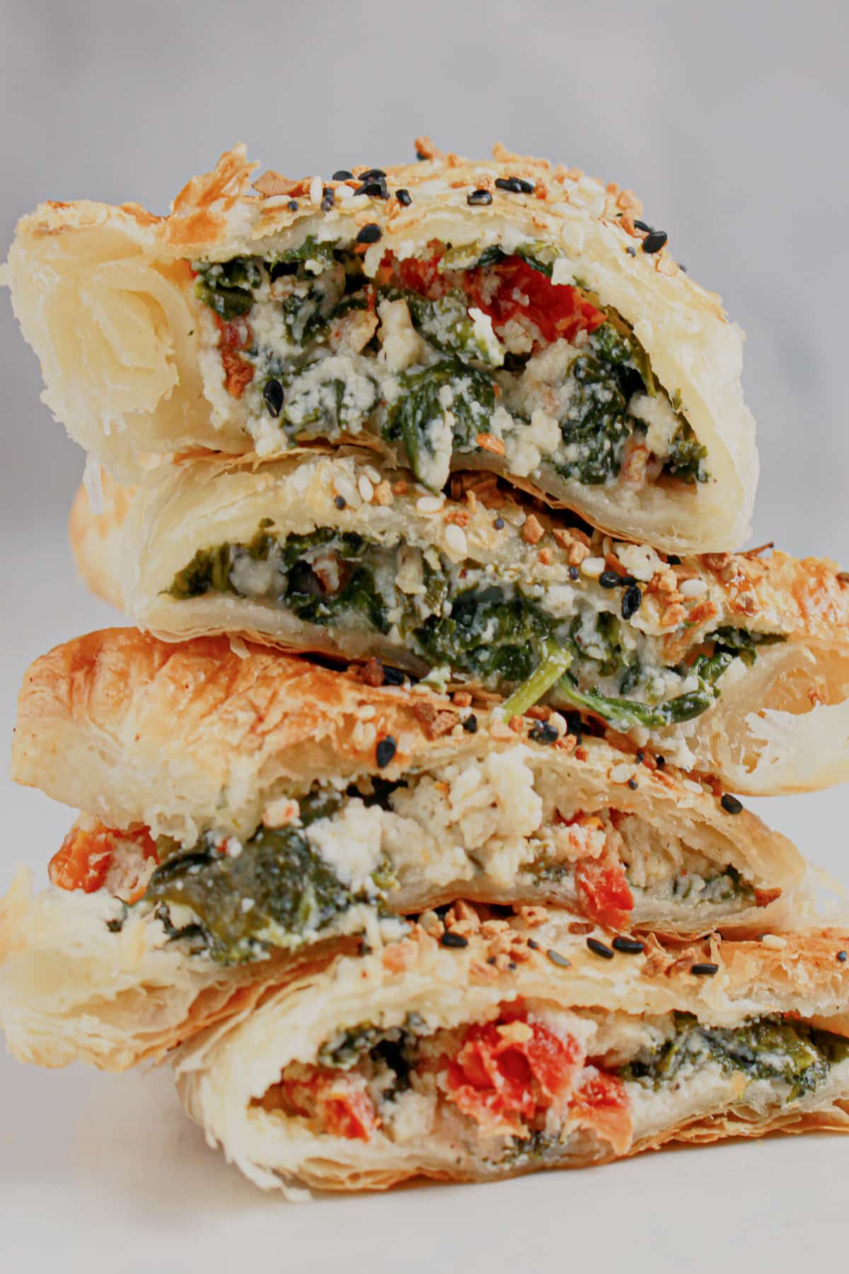 Cheese spinach puff pastries stacked.
