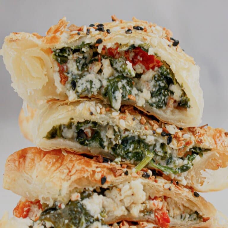 Cheese spinach puff pastries stacked.