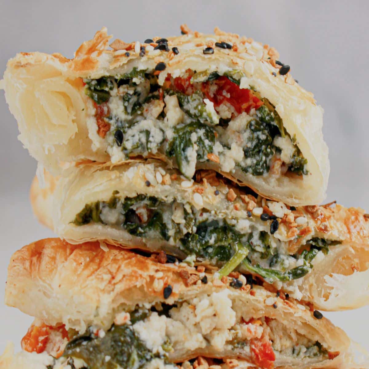 Cheese spinach puff pastries stacked.