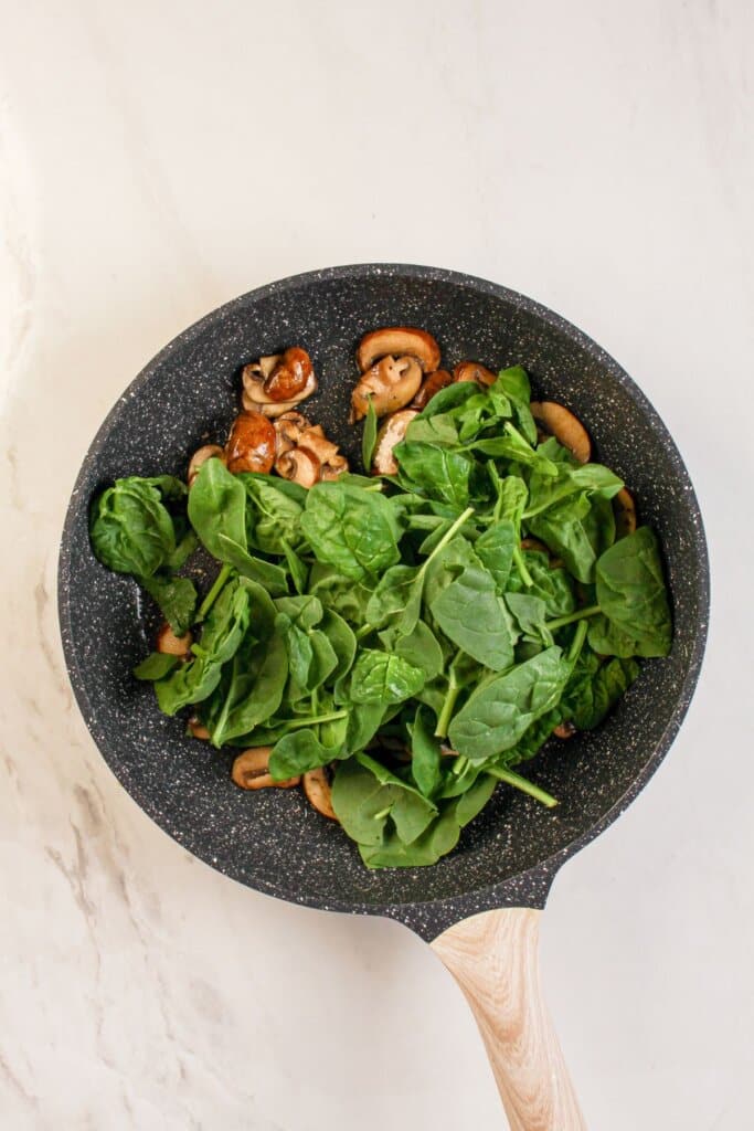 Spinach and mushrooms in a pan.