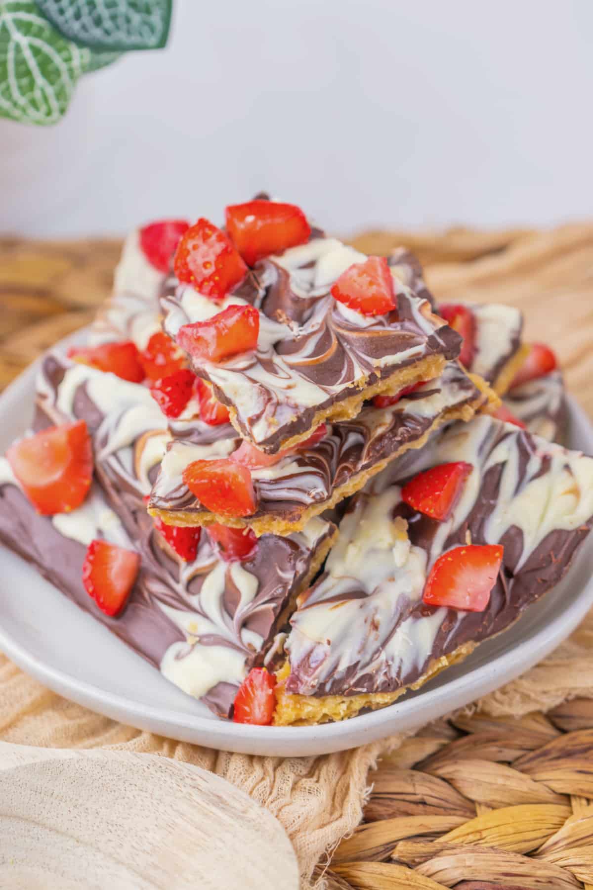 Stack of chocolate covered strawberry bark on a plate.