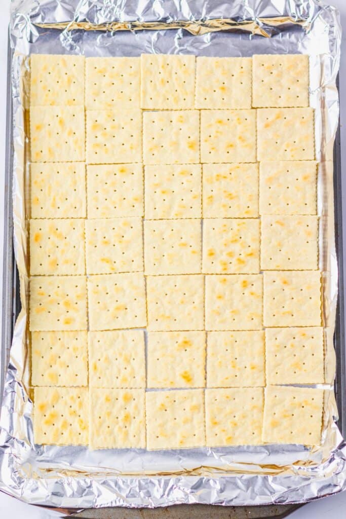 Saltine crackers on a foiled lined baking sheet.