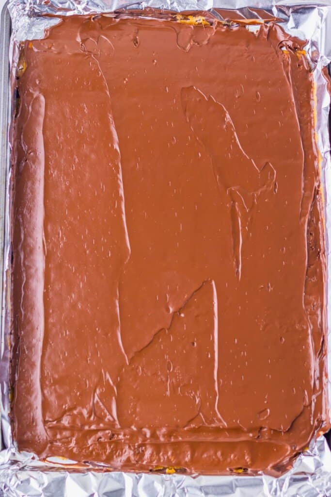 Chocolate being spread on top of crackers.