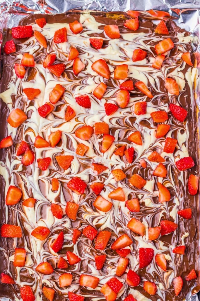 Fresh fruit sprinkled on top of crackers.