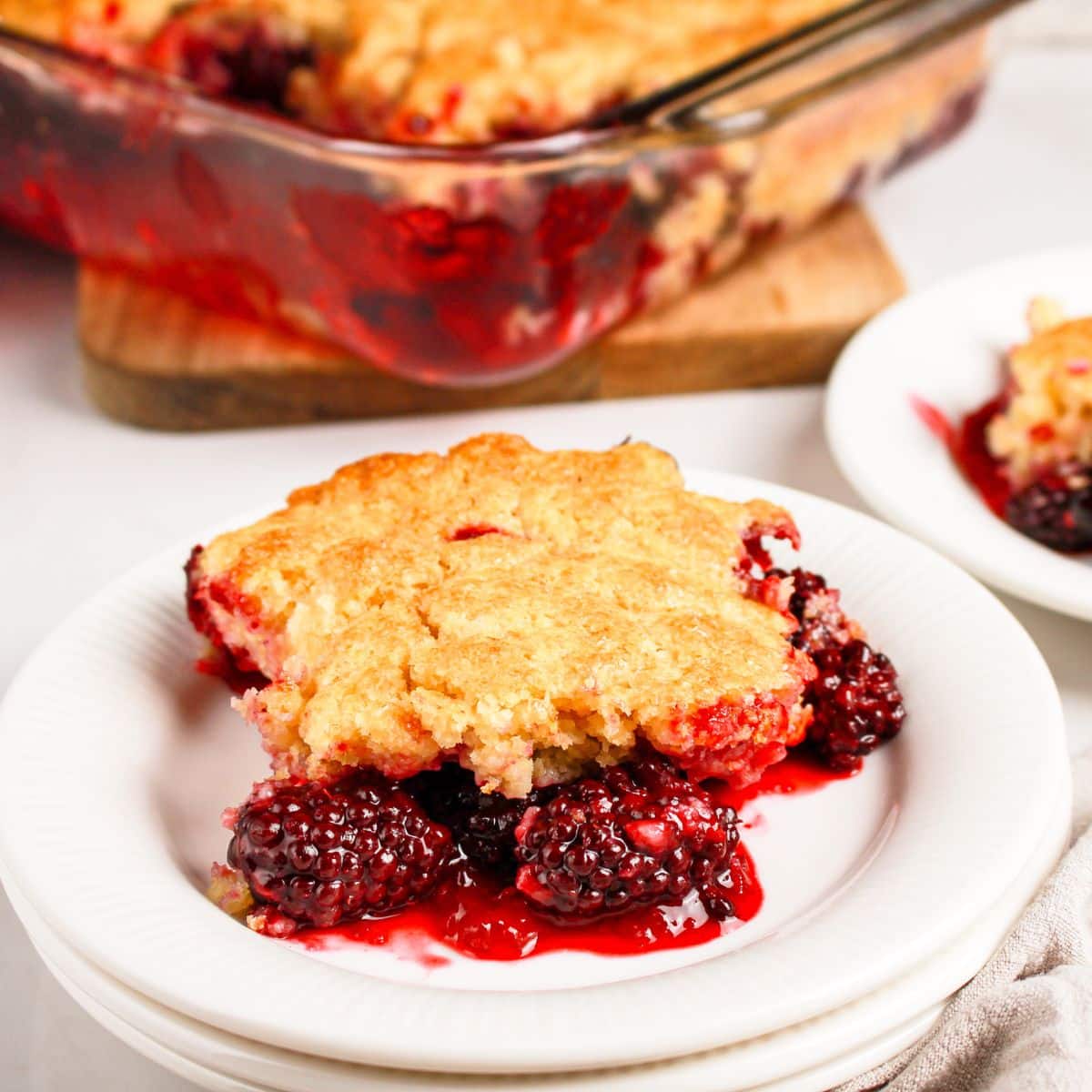 Slice of blackberry cobbler on a small plate.