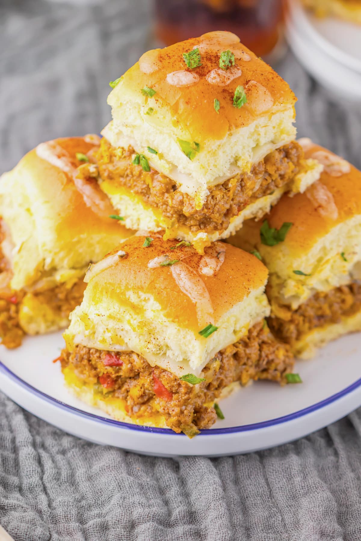 Enchilada sliders stacked on a plate.