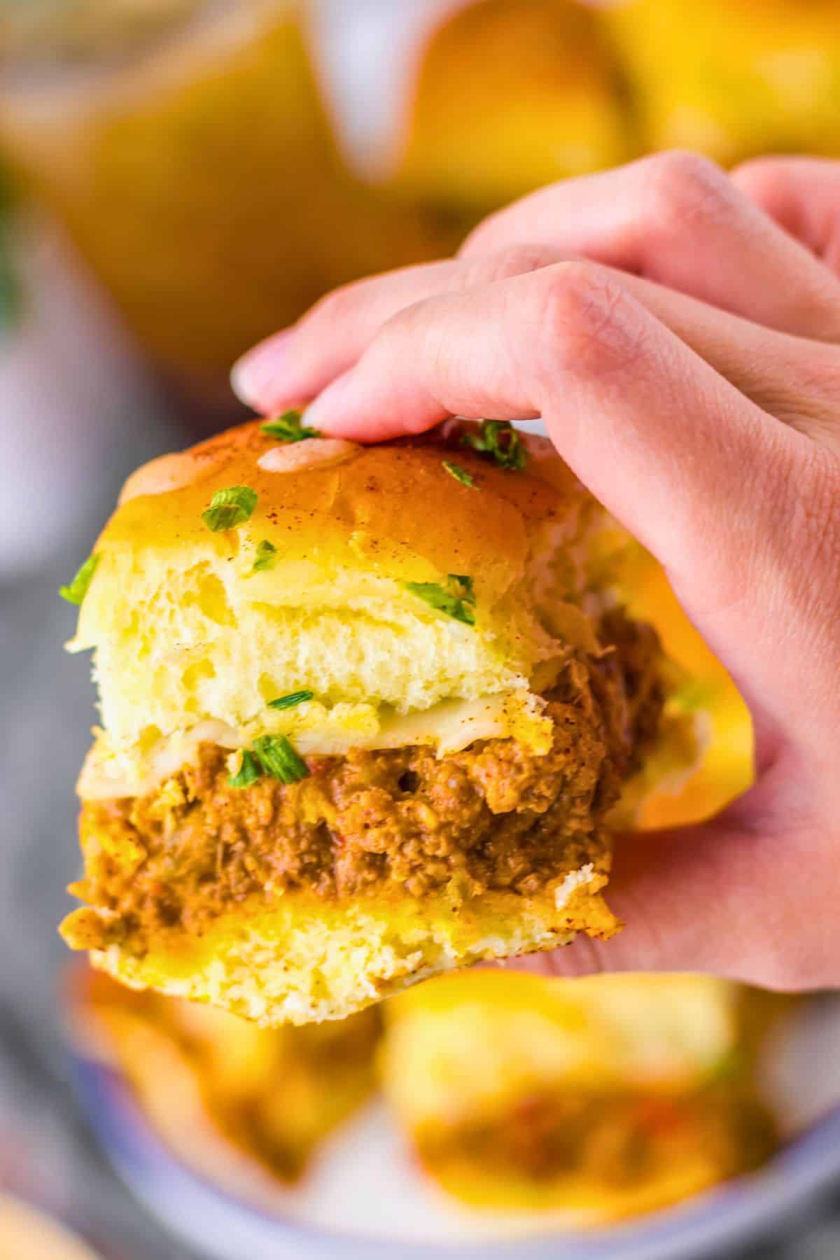 Enchilada slider held in a woman's hand.