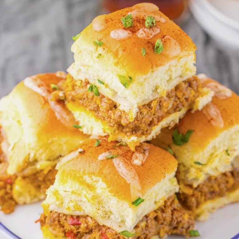 Enchilada sliders stacked on a plate.