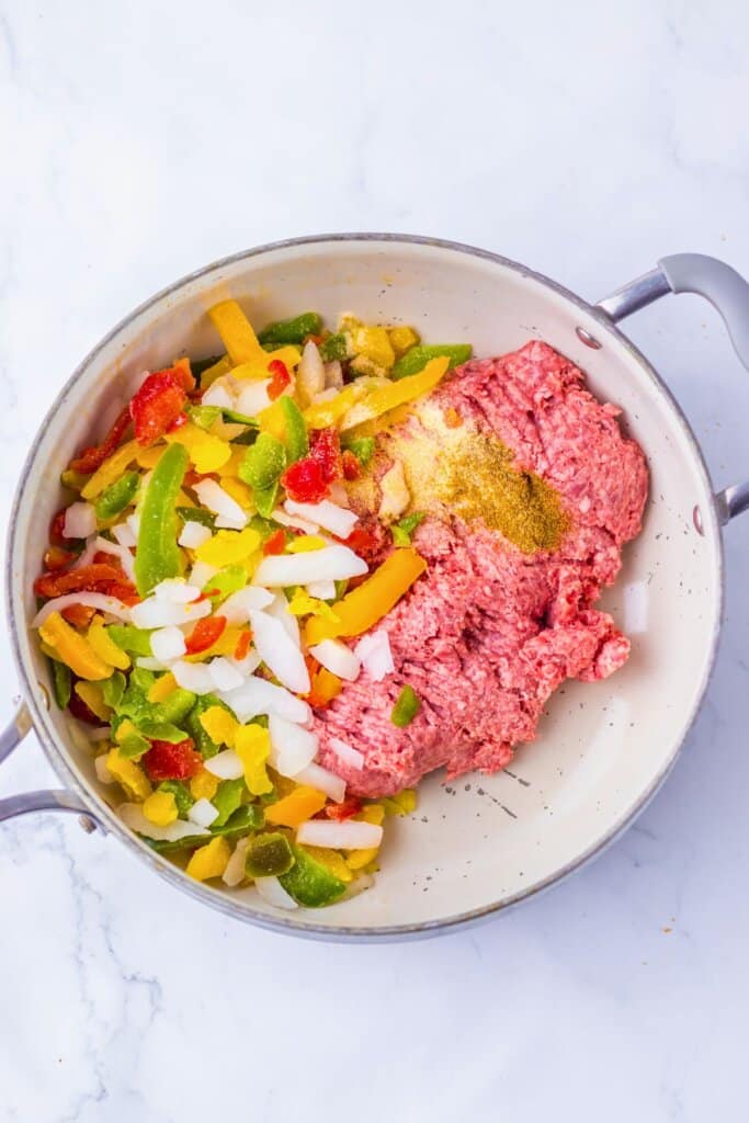Beef and veggies being cooked in a skillet.