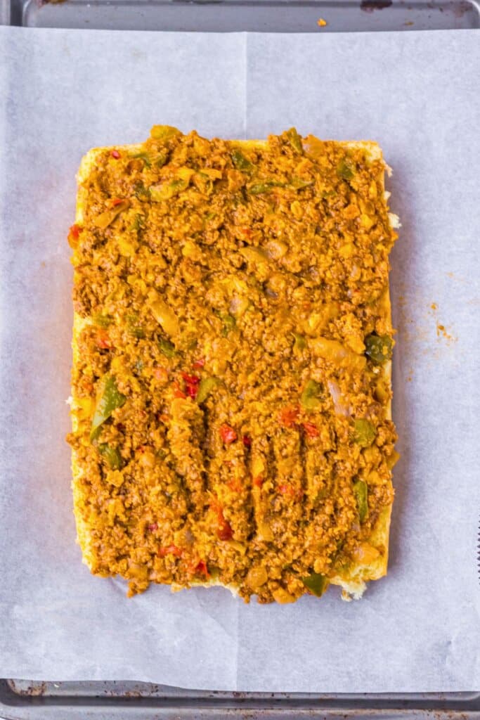 Meat and veggie mixture on top of rolls.