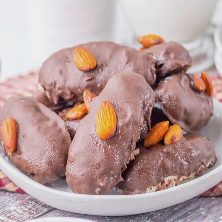 Homemade almond joys stacked on a plate.