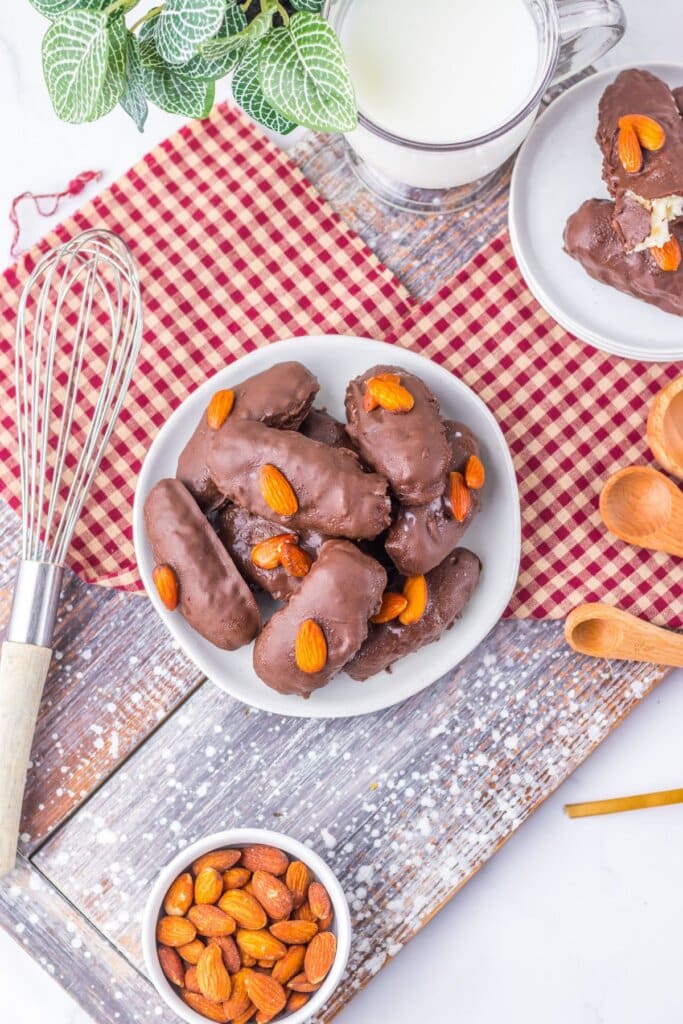 Homemade almond joys stacked on a plate.