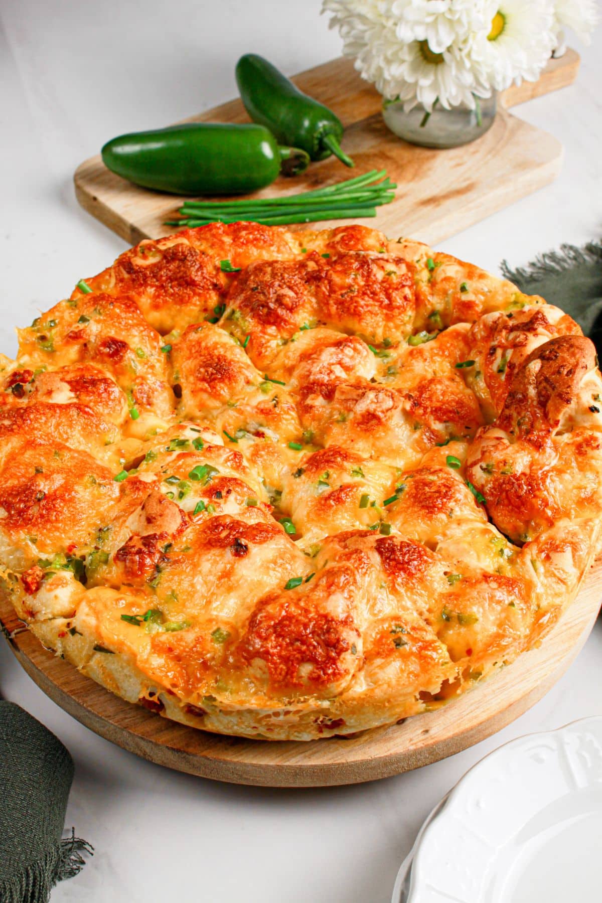 Jalapeno cheddar pull apart bread on a wooden cutting board.