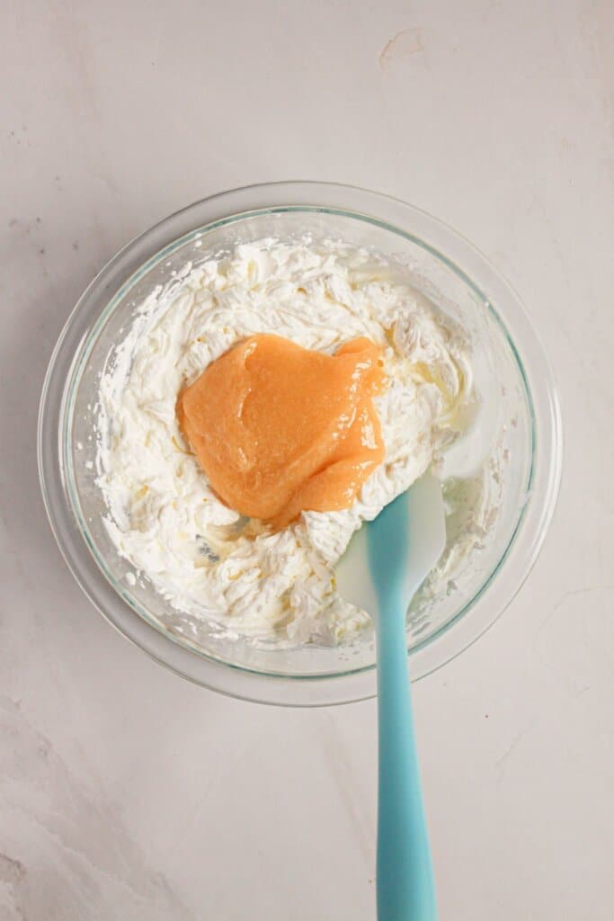 Curd being mixed into whipped cream.