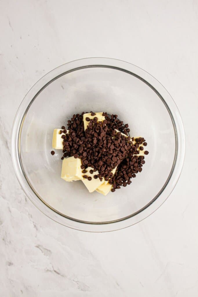 Chocolate and butter being melted together in a glass bowl.