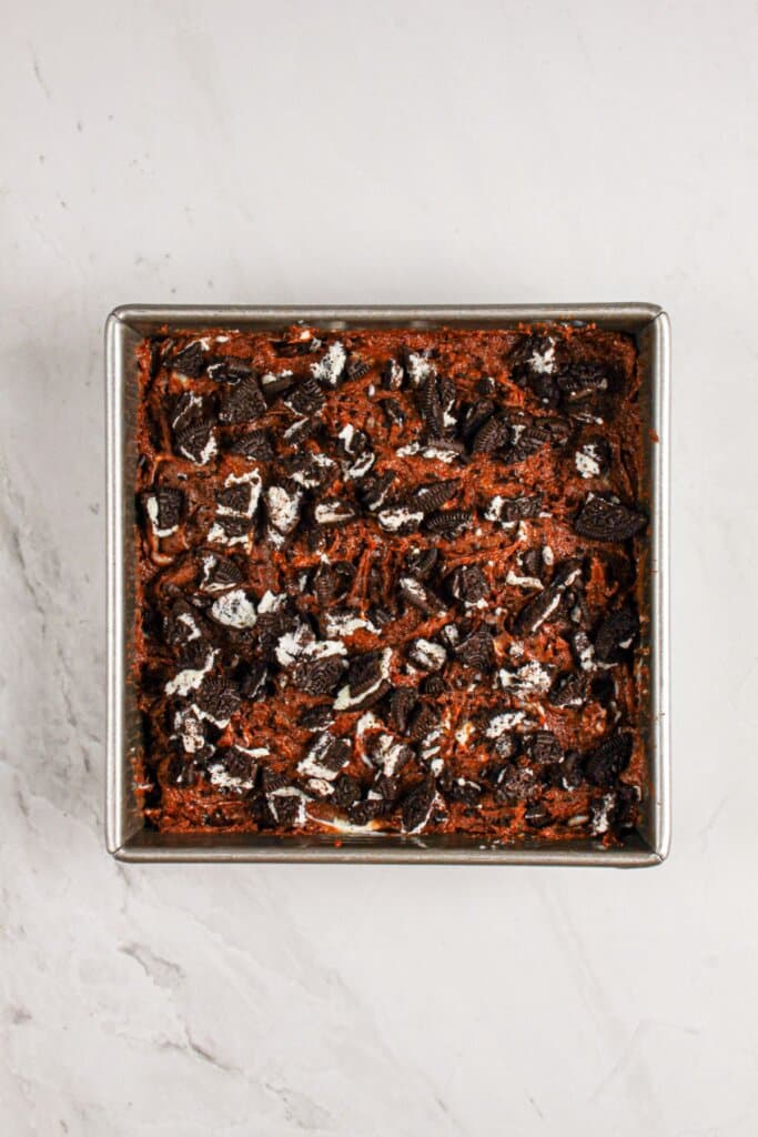 Batter topped with cookies in a baking pan.