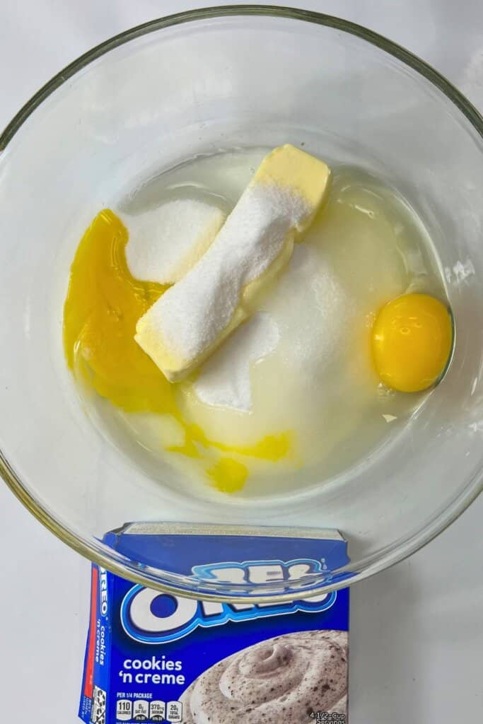 Eggs and butter being mixed in a glass bowl.