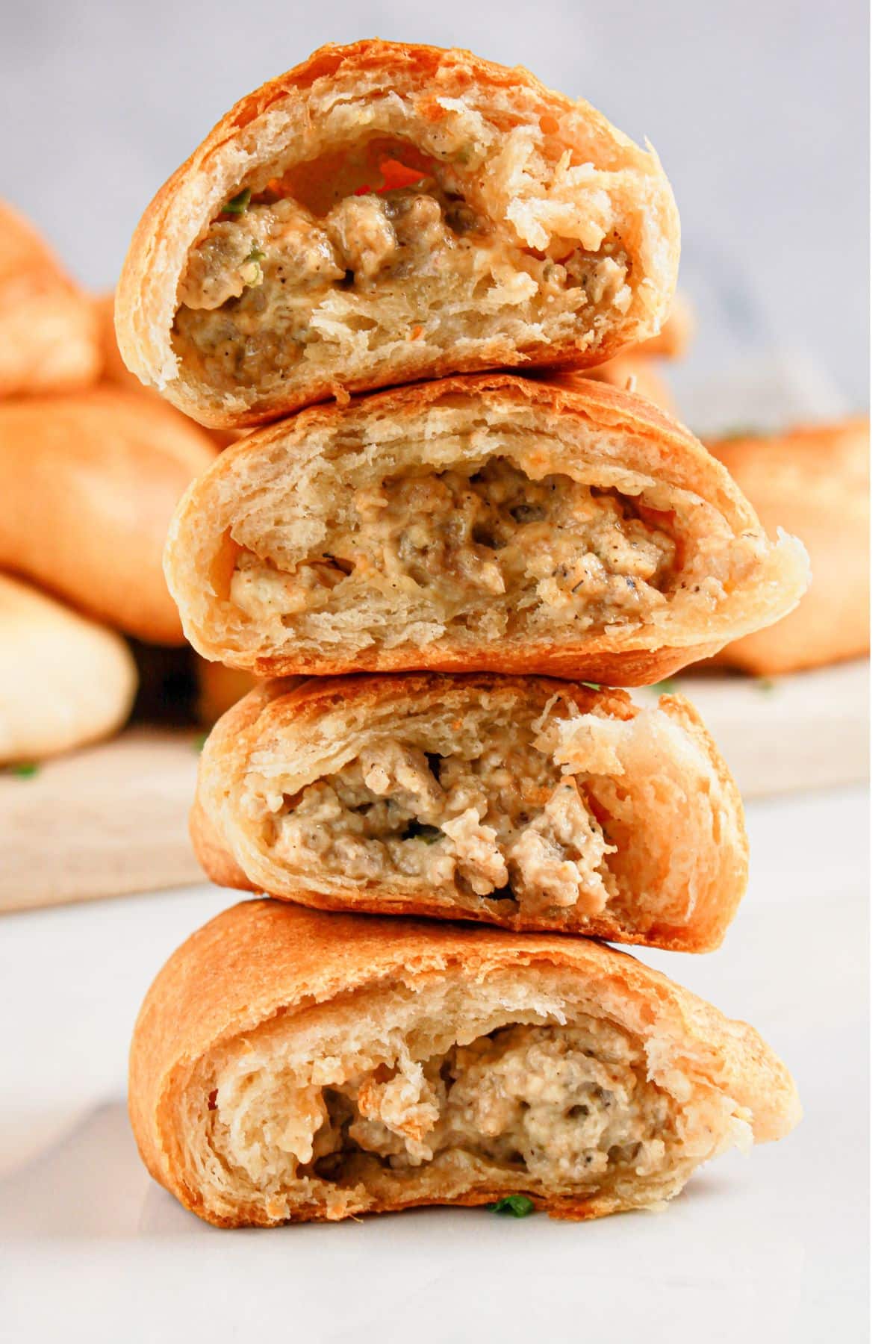 Crescent rolls broken in half stacked on top of each other.