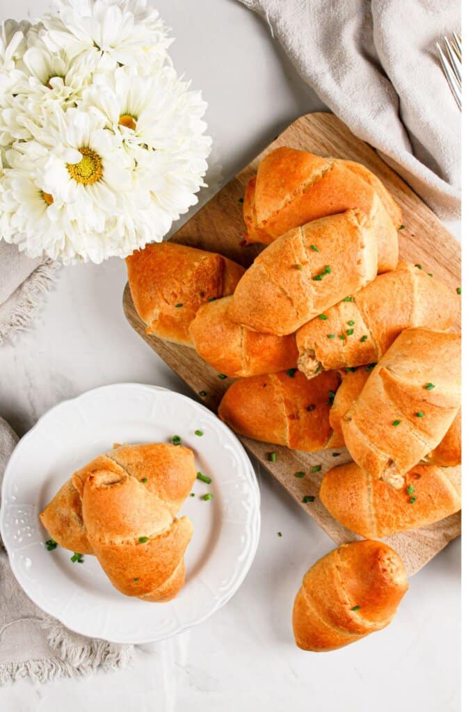 Sausage crescent rolls stacked on a plate.