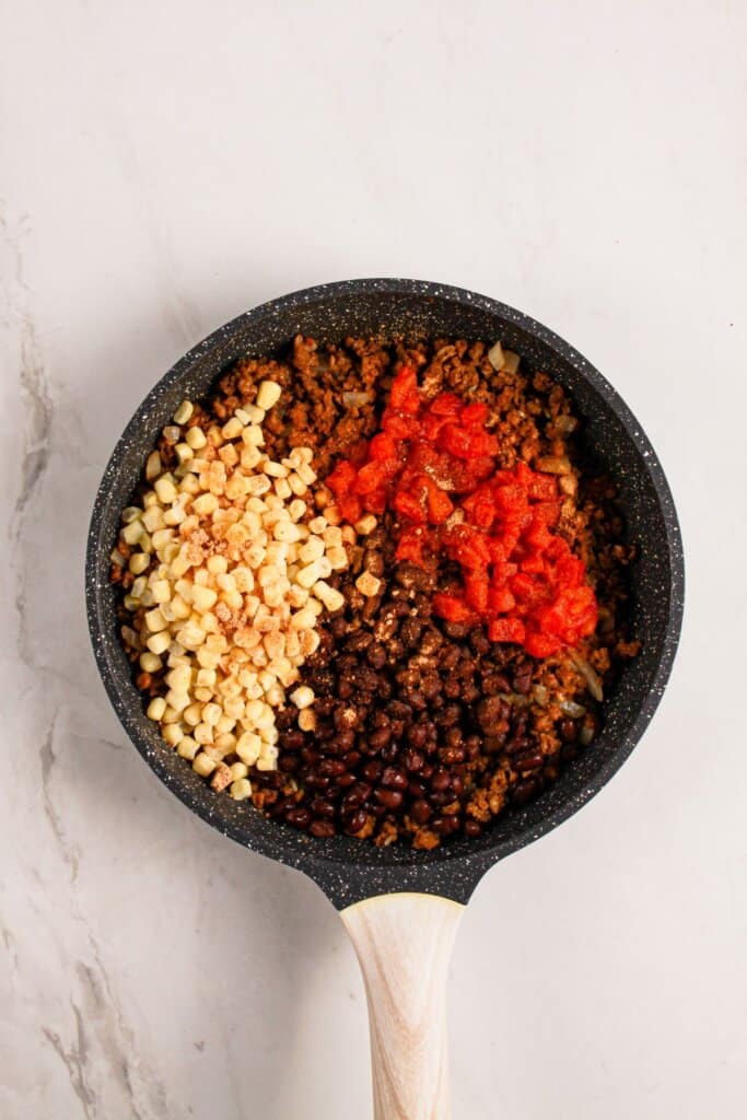 Beef, beans, and vegetables in a skillet.