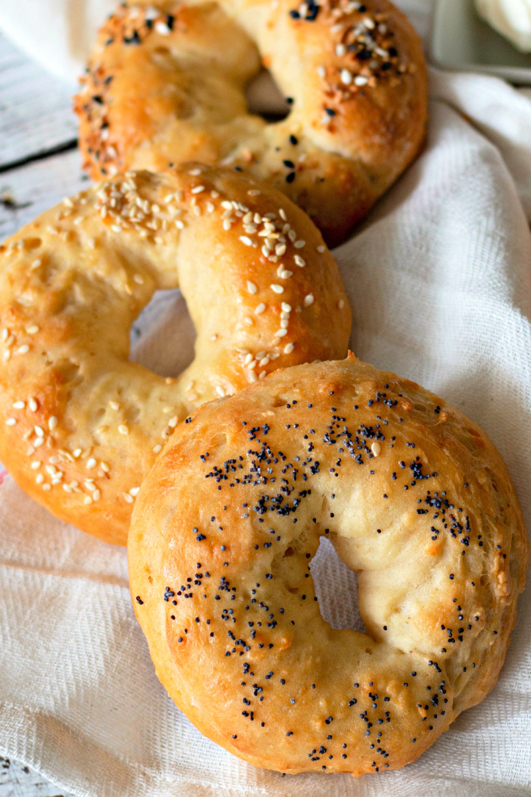 Three greek yogurt protein bagels on a kitchen counter.