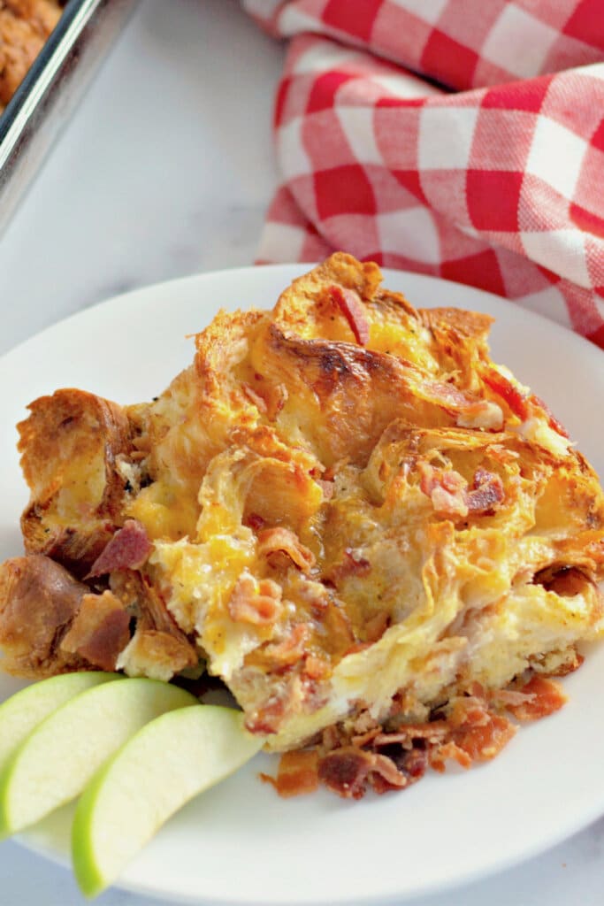 Serving of bacon croissant breakfast casserole on a plate.