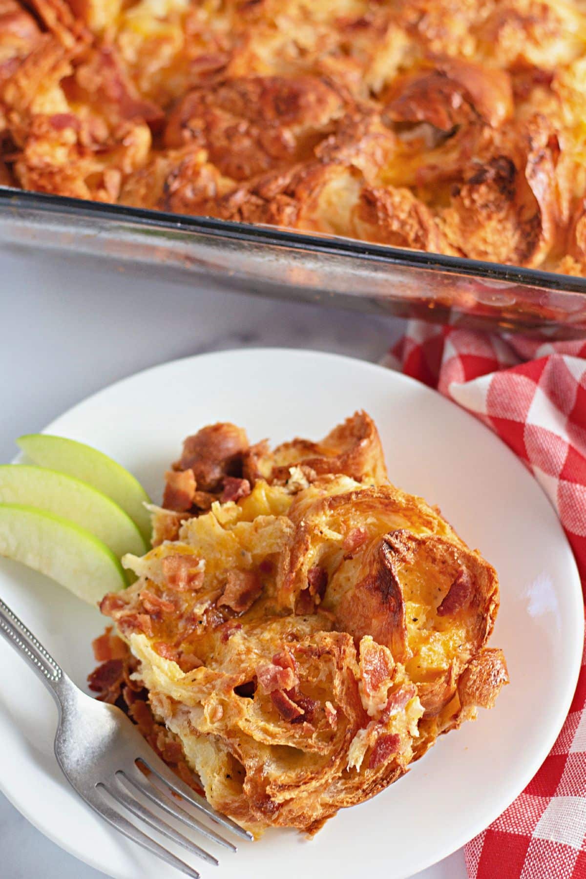 Serving of bacon croissant breakfast casserole on a plate.