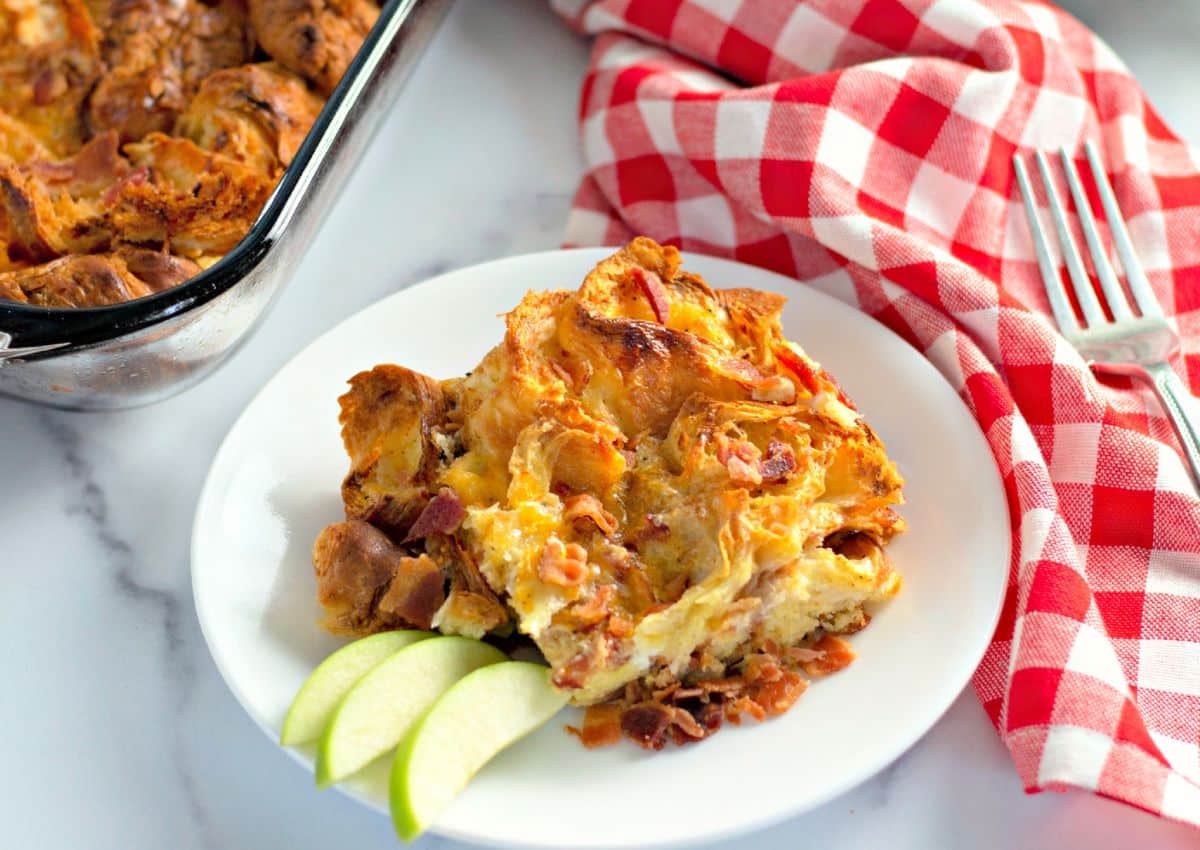 Serving of bacon croissant breakfast casserole on a plate.