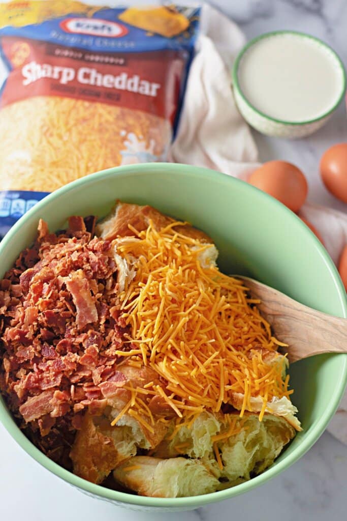 Bacon, cheese, and bread pieces in a bowl.