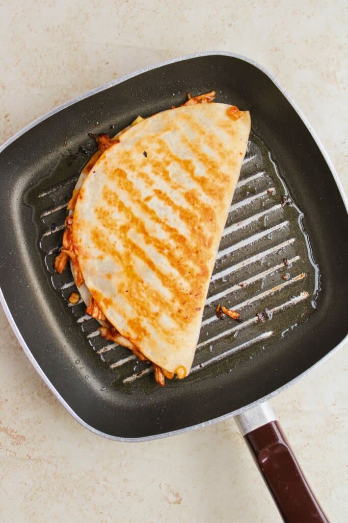 Tortilla being browned in a skillet.