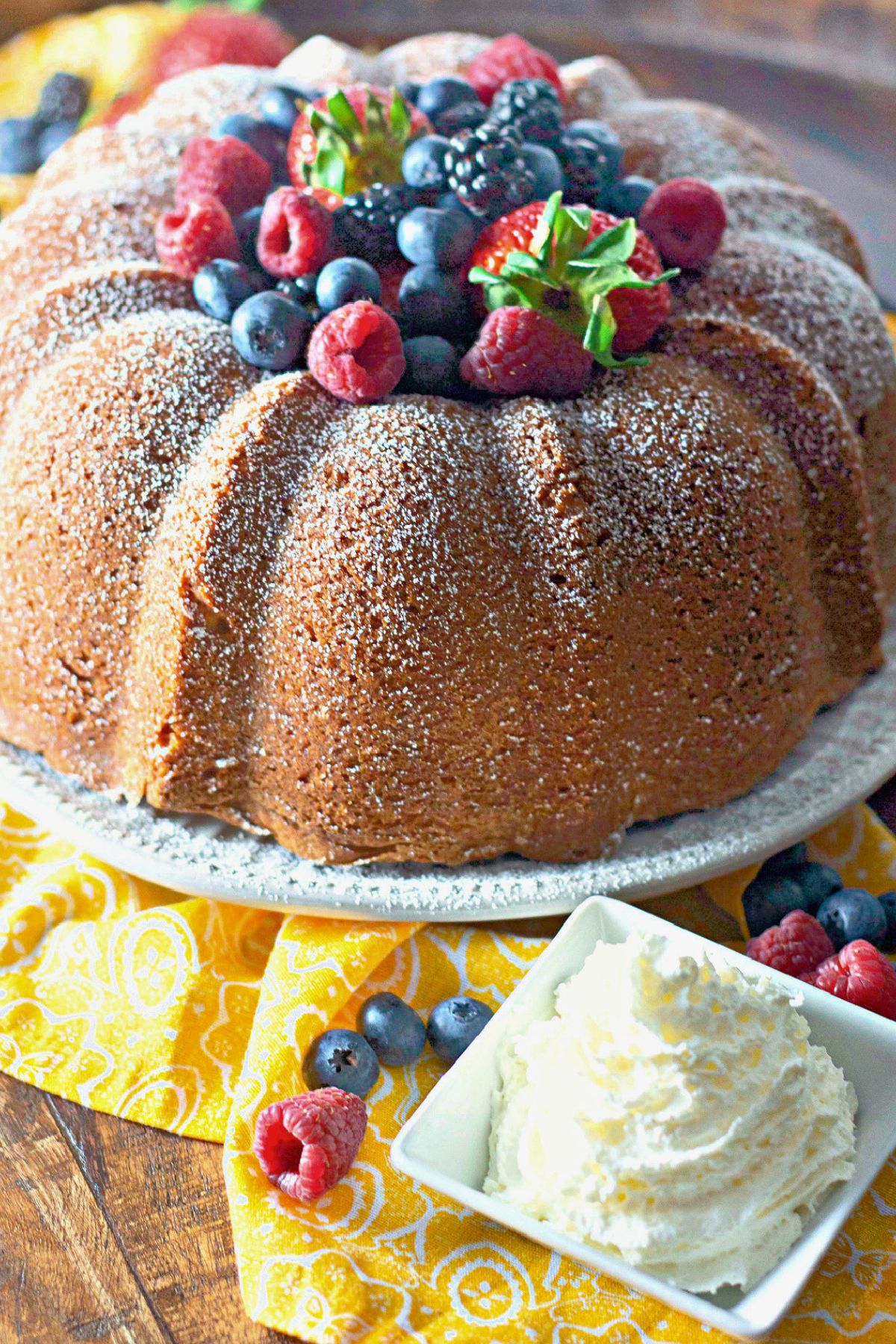 Full cream cheese pound cake on a cake plate.